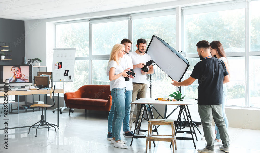 Wall mural mentor teaching young photographers in studio