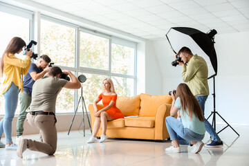 Young photographers taking picture of woman in studio