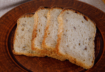 sliced pieces of bread are on a ceramic plate. Sourdough bread.