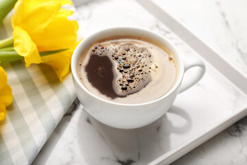 Cup of coffee with flowers on tray, closeup