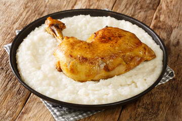 Saleeg arabic risotto made from creamy white rice with chicken quarters close-up in a plate on the table. horizontal