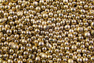 A background of many shiny yellow metal balls.