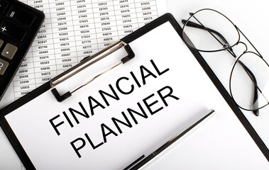 Paper with FINANCIAL PLANNER on a table with pen, glasses and chart