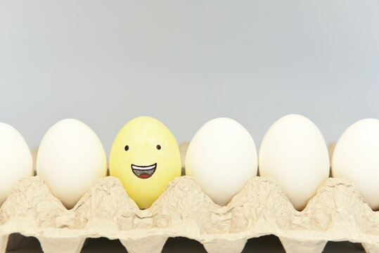 Laughing face emoticon, grinning from ear to ear, illustrated on an egg shell.