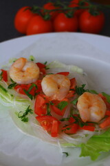 Spring rolls with prawns, tomatos and salad in the preparation