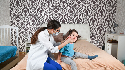 The doctor checks the child's ears at home