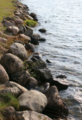 Northern stones near the shore of the reservoir. Natural background