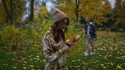 Close up view of dreaming stylish girl in plaid shirt and had holding leaves.
