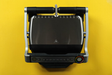 Modern electric grill on yellow background, top view