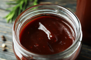 Glass jar of tasty barbecue sauce, close up