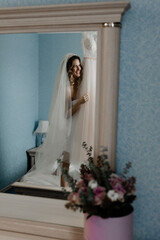 beautiful bride of European appearance hugs a wedding dress. joyful bride in a dressing gown is going to dress in the room