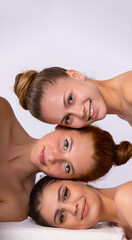 Naturally beautiful three caucasian diverse women with flawless fresh skin. Spa, beauty, wellness concept. Facial treatment, Perfect skin, Natural make up on gray background.