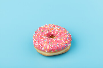 Fresh made Donuts isolated on blue background. Doughnuts are traditional sweet pastries. Copy space for text.