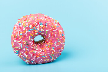 Fresh made Donuts isolated on blue background. Doughnuts are traditional sweet pastries. Copy space for text.