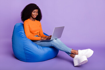 Portrait of attractive focused cheerful wavy-haired girl copywriter sitting using laptop isolated...