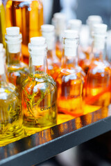 Glass bottles with flavored olive oil. Oil with rosemary and spices.