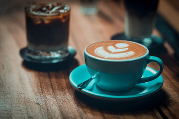 Cappuccino coffee placed on a wooden table With the afternoon break.