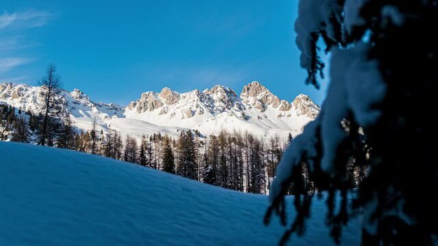 Snow-capped mountains on sunny day near San Pellegrino lake. Motionlapse