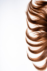 Dark hair curls lie on white background