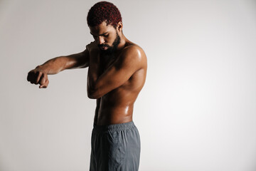 Fototapeta na wymiar Black shirtless sportsman doing exercise while working out