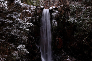 Fototapeta na wymiar Tsutsumigataki Waterfall with Snow Makeup under Shade