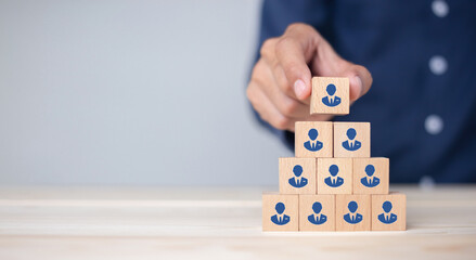 Concept of human resource management and recruitment business Hand put wood cube block on top pyramid To business success concept. - obrazy, fototapety, plakaty