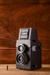cámara analógica TLR de formato medio 6x6 en una mesa junto a una figura de un anciano a escala OO