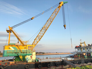 Fototapeta na wymiar Crane Barge parked in the harbor has a blue sky at dusk.cargo ship.sea freight