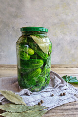 Pickled cucumbers in glass jar with dill on a gray wooden table.  Vegetarina, organic food, ready for winter.