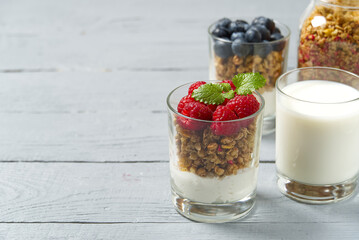 Yogurt with granola and fresh blueberries and raspberry, in glass. Healthy breakfast: yogurt parfait with granola and berries