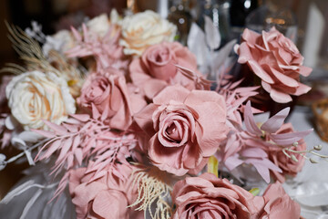 Bouquets artificial fabric roses close up at home interior. Wedding or celebration decoration concept