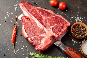 raw T-Bone Beef Steak on the knife on stone background
