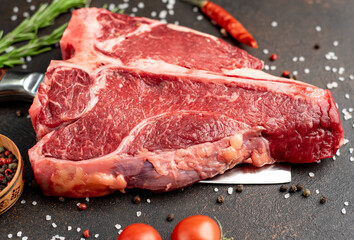 raw T-Bone Beef Steak on the knife on stone background
