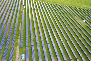 Aerial view of solar power plant on green field. Electric panels for producing clean ecologic energy.
