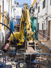 Yellow excavator fixing Postigos street