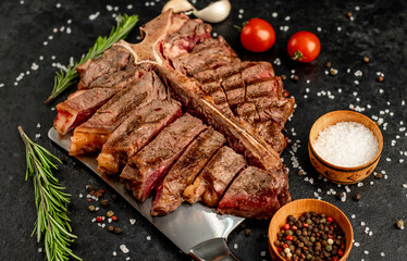 Grilled T-Bone Beef Steak on a knife on a stone background