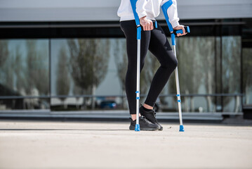 girl with crutches, sideways walking alone