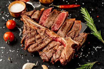 Grilled T-Bone Beef Steak on a knife on a stone background