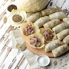 Stuffed cabbage rolls with meat. Cooking process. Homemade preparations, minced meat and rice on cabbage leaves. Raw convenience foods on kitchen table.