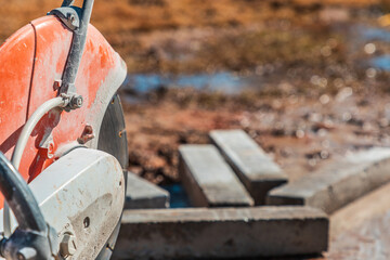 Closeup of a demo saw used to cut paver stones on a landscaping job site