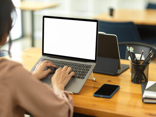 Businesswoman working with laptop on wooden desk in office room