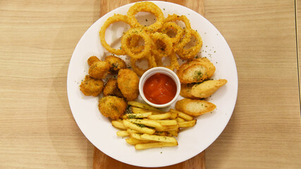Onion ring mix with french fries, mushroom served on large plate
