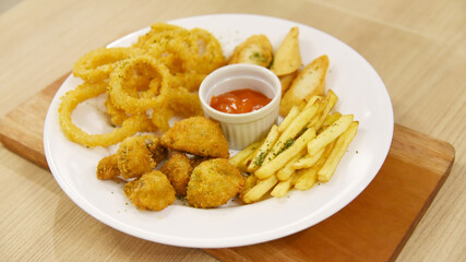 Onion ring mix with french fries, mushroom served on large plate