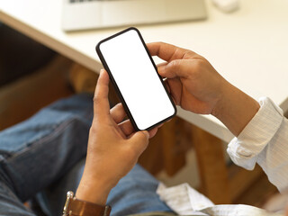 Male hands using smartphone while relaxed sitting in office room