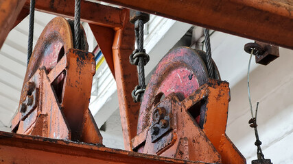 Details of lifting mechanism of bucket grab in industrial plant. Steel wire rope and wheels close-up