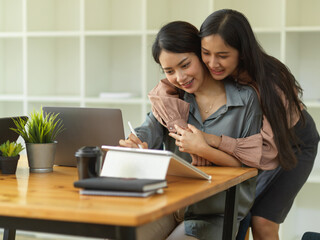 Lovely couple hugging while working on office desk in home office room