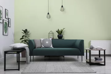 Foto op Aluminium Stylish living room interior with comfortable green sofa and floral pictures © New Africa