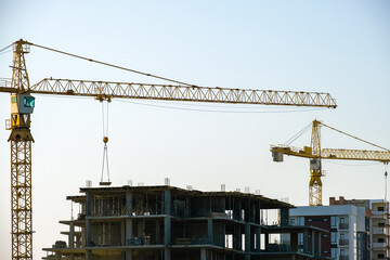 Aerial view of tower cranes and high residential apartment buildings under construction. Real estate development.