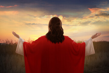 Jesus Christ outdoors at sunset, back view