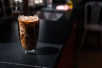 Close-up glass of iced coffee with milk on the table